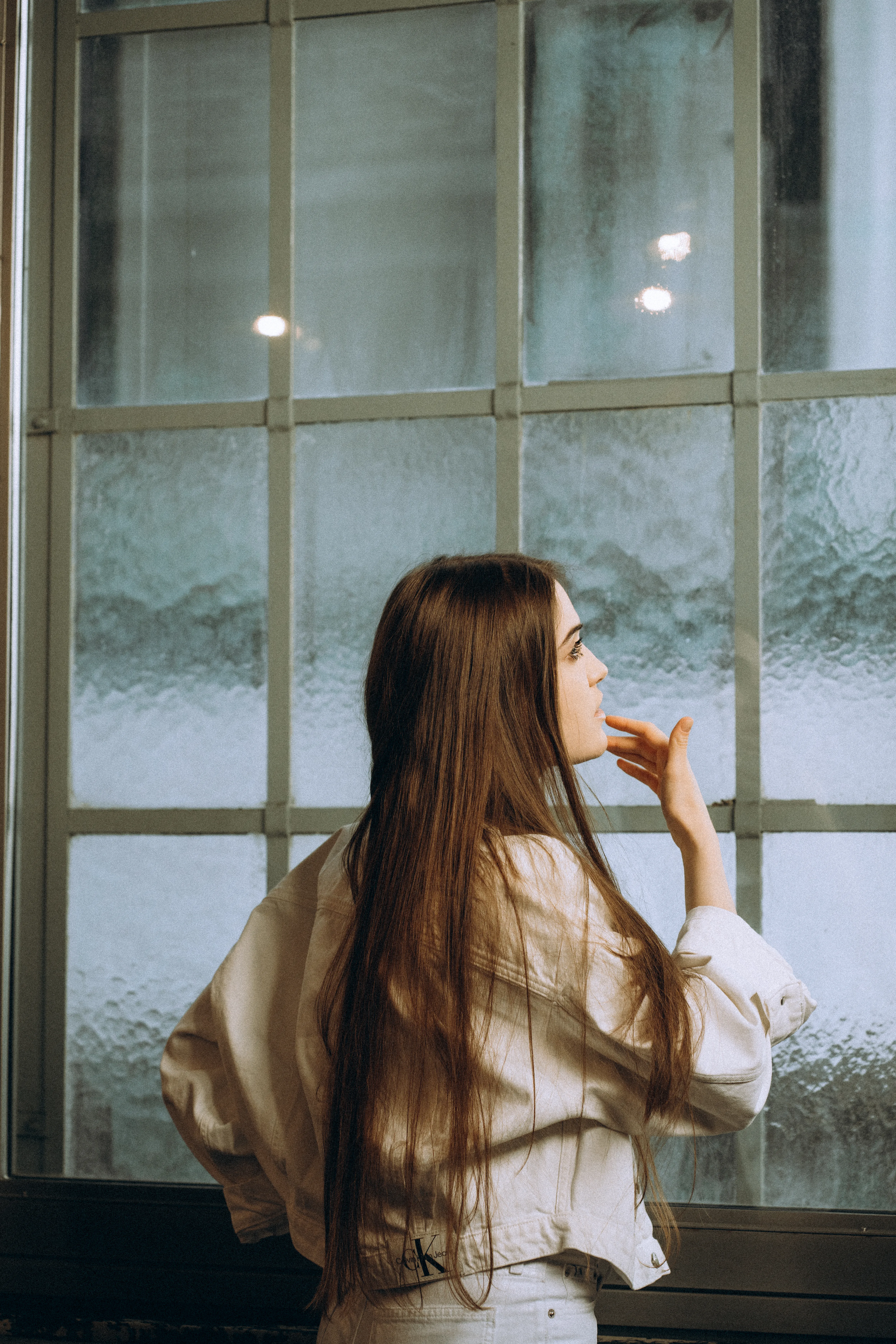 A woman looking toward a window in a cinematic portrait