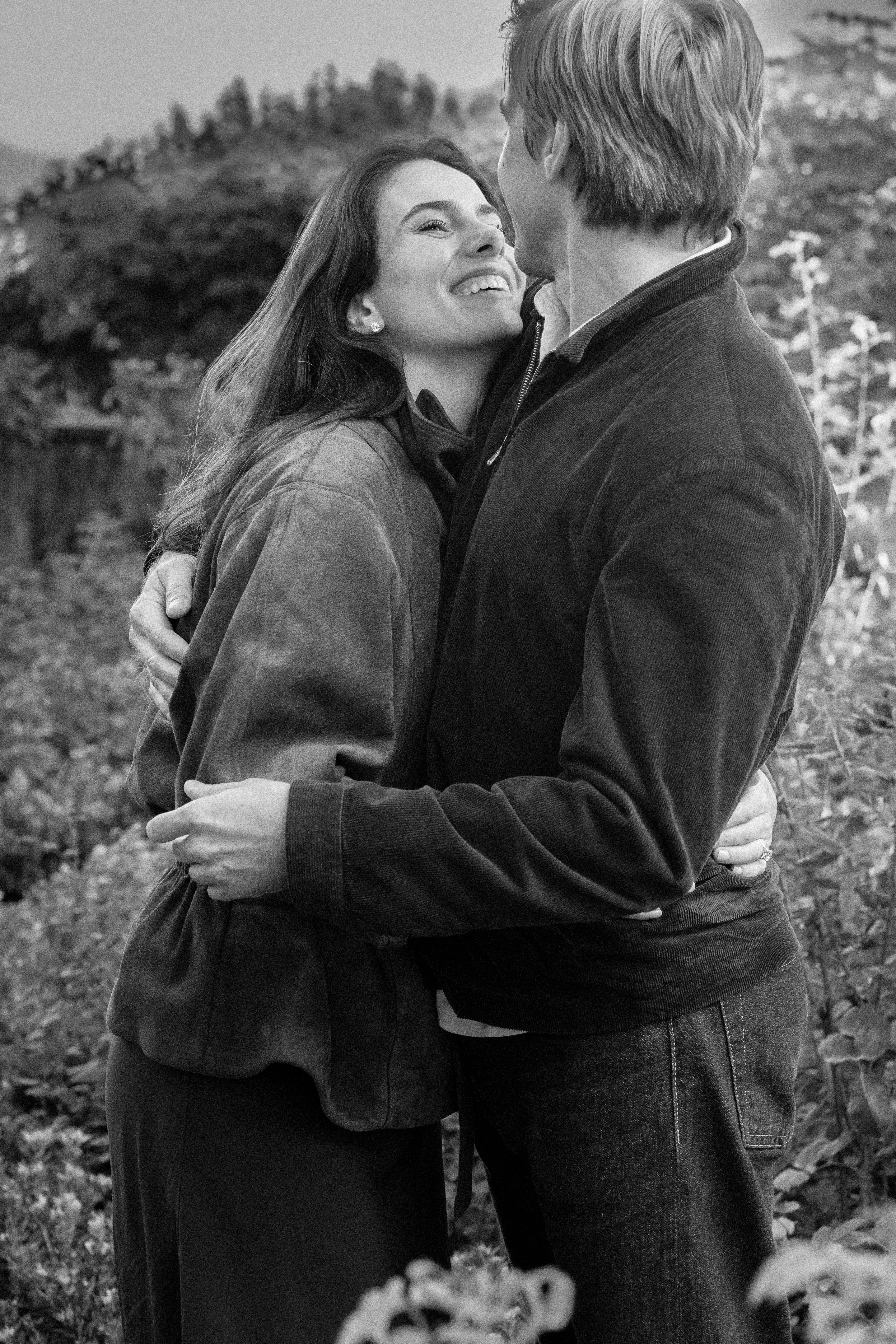 A couple embracing outdoors in a monochrome photograph