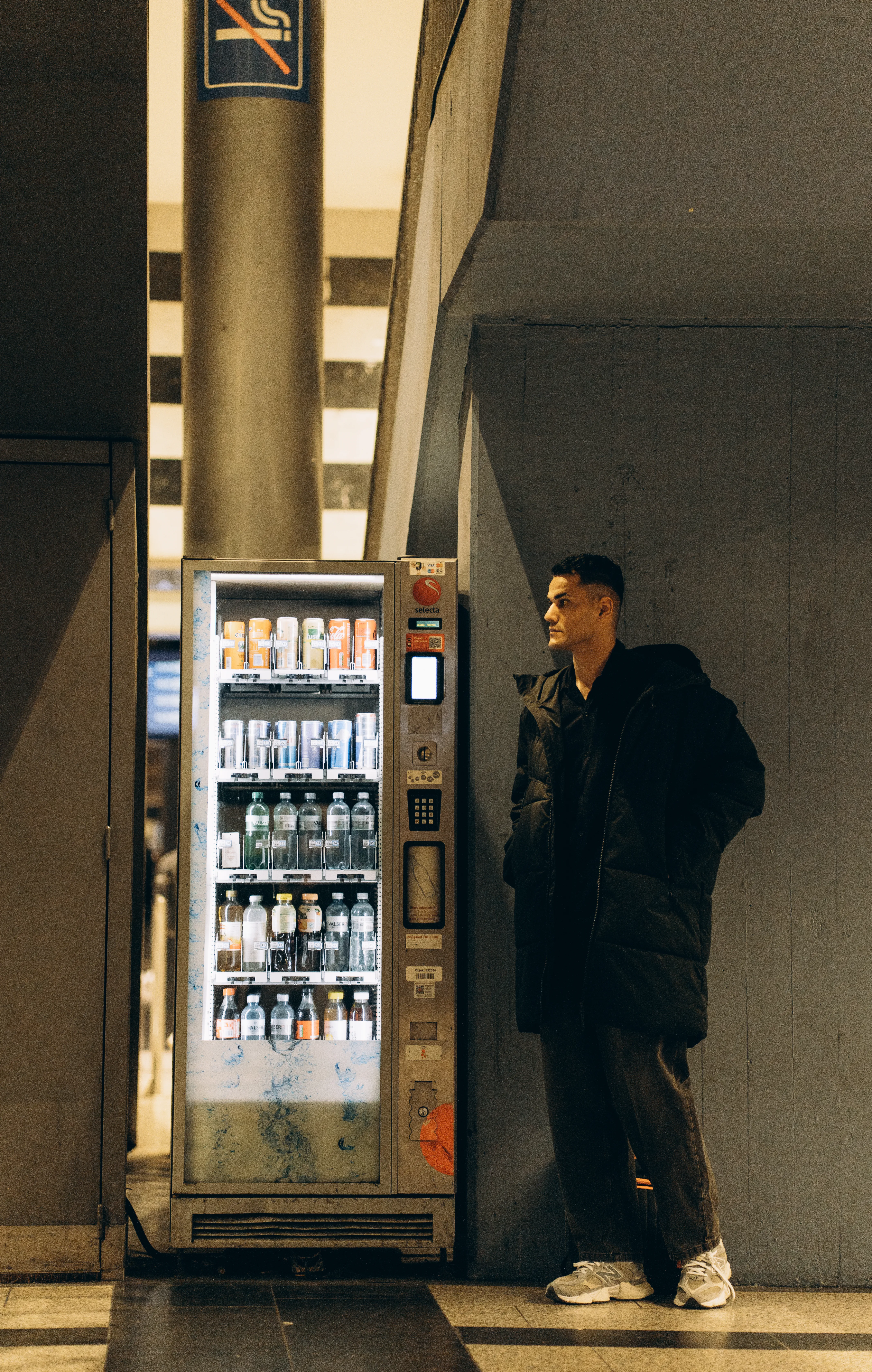 A person standing beside a vending machine